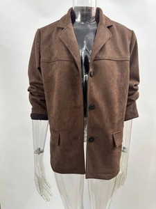 Detailed close-up of brown suede blazer texture featuring classic lapels and buttons