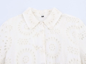 Detailed close-up of white cotton embroidery and neckline on this elegant shirt dress