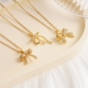 French vintage gold bow necklace with sparkling zircon pendants on a podium