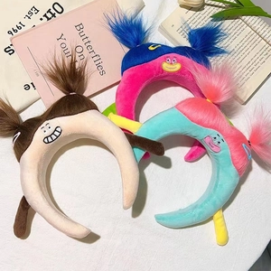 Close-up of colorful plush cartoon headbands featuring embroidered faces and long yarn hair