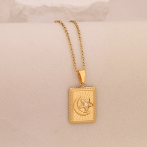 Detailed macro view of the gold crescent moon and star pendant on a textured necklace