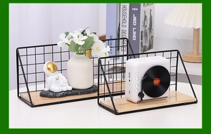 Detailed view of Nordic black metal wall shelf with light wood base in home setting