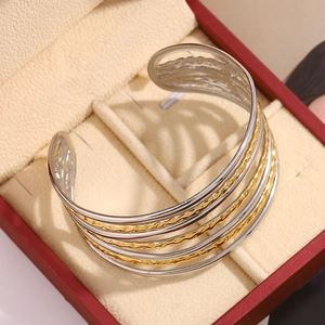 Détail d'un bracelet jonc multicouche or et argent dans un écrin de luxe
