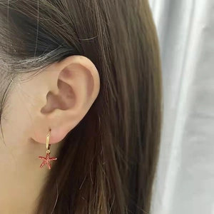 Fashion S925 silver needle gold hoop earrings with red starfish pendant worn by a model