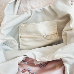 Detail view of jacquard butterfly bag interior with silky lining and zipper pocket