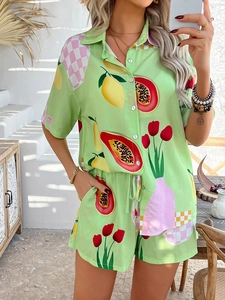 Lifestyle shot of woman in vibrant green tropical papaya print shirt and shorts set