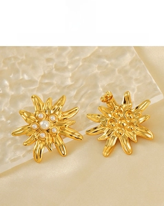 Détail de boucles d'oreilles fleurs plaquées or 18 carats avec perles et design en étoile
