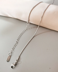 Macro shot of silver stainless steel snake chain showing lobster clasp and S.STEEL tag