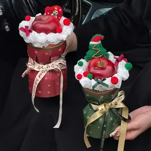 Handheld Christmas apple gift bouquet with red paper wrap and festive ribbons