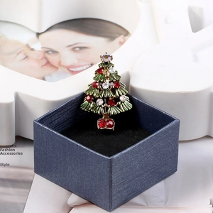 Detail of Christmas tree brooch with green enamel and rhinestones in blue gift box