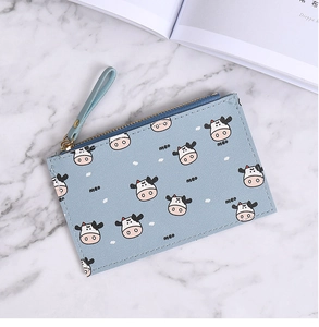 Close-up of light blue cow print coin purse with a zipper and convenient wrist strap
