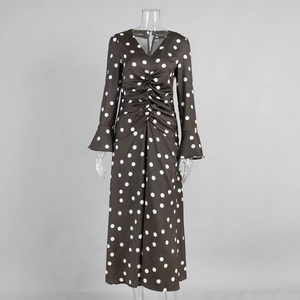 Détails du col en V et de la taille froncée d'une robe longue marron à pois blancs