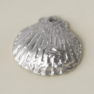 Détail macro d'un pendentif coquillage en acier inoxydable 304 avec texture océan