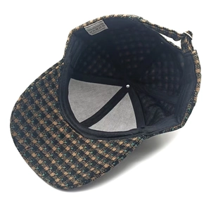 Detail view of houndstooth wool baseball cap inner lining with adjustable metal buckle