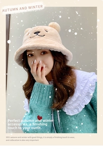 Close-up of plush bear ears and embroidered facial details on a beige winter bucket hat