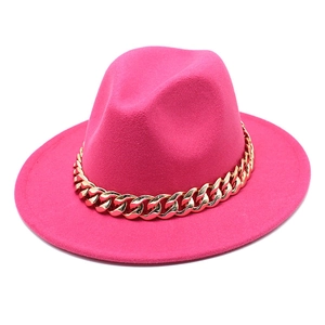 Detail of rose pink wool jazz fedora hat featuring a chunky gold chain decoration