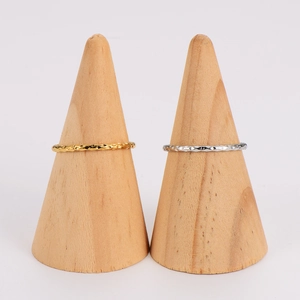 Minimalist wavy textured rings in gold and silver finish on wooden jewelry stands