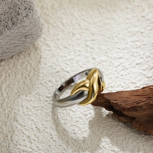 Detail of two-tone 18K gold and silver wide double-layer ring on rustic wood background