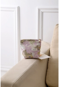 Vue détaillée de la trousse à maquillage en jacquard rose avec fermeture éclair fleur dorée