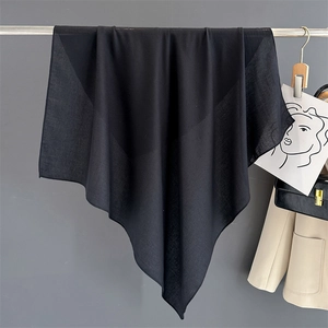 Detailed texture of black cotton linen square scarf hanging on a grey wall