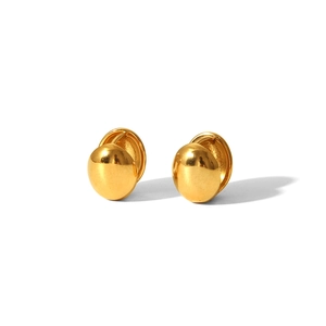 Gros plan détaillé de boucles d'oreilles dorées en forme de haricot avec fini poli miroir