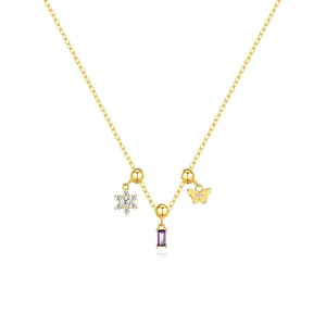 Close-up of gold necklace featuring snowflake, purple gemstone, and butterfly charms