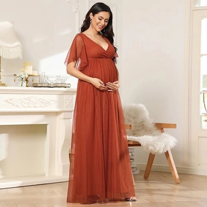 Detail of the high-waisted maternity gown in rust red tulle with elegant V-neckline