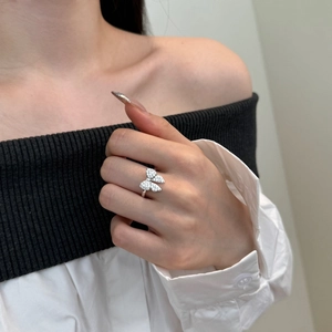 Close-up of a silver bow ring with zircon butterfly wings worn by a female model