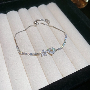 Close-up of adjustable silver bracelet with zircon pavé heart and star pendants on velvet