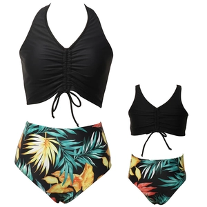 Set bikini coordinato mamma e figlia con top nero a cavezza e slip a stampa tropicale