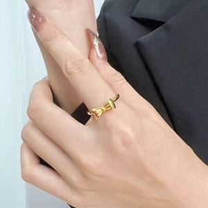 Golden bow-shaped titanium steel ring for women displayed on model with professional style