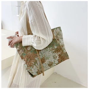 Detail of artistic sunflower tote bag with woven texture and synthetic leather strap