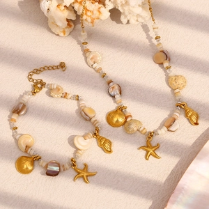 Detailed view of 18K gold plated necklace and bracelet set with starfish and shell pendants