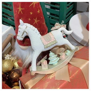 Festive rocking horse decoration with pink saddle and small Christmas trees on the base