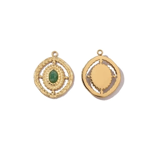 Macro shot of gold circular pendant with green oval stone inlay showing both sides