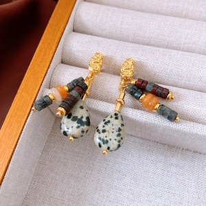 Detail of vintage beaded earrings with teardrop stones in a velvet jewelry box