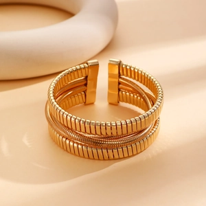 Ampio bracciale elastico multifilo dorato con maglia intrecciata e trame a spirale