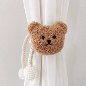 Detail of plush teddy bear curtain tieback with woven rope and pearl bead closure