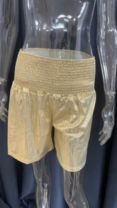 Detail view of gold metallic texture and elastic waistband on loose sport shorts