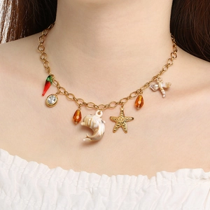 Collier d'été doré avec breloques étoile de mer et dauphin porté par un modèle