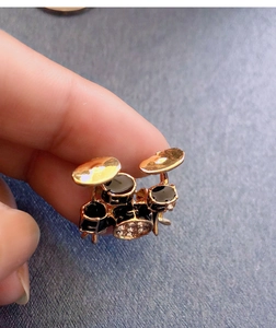 Macro shot of a mini drum kit brooch with sparkling rhinestones and gold finish