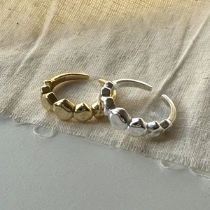 Detail of irregular faceted S925 sterling silver open rings in gold and silver finishes