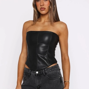 Détail d'un haut bustier en cuir PU noir avec ourlet en V et coutures verticales
