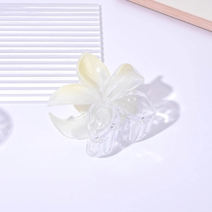 Detail shot of a transparent 8cm plumeria hair claw clip with yellow gradient finish