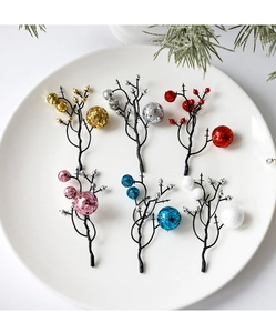 Detail of glitter and metallic Christmas berry picks in six colors on a white plate