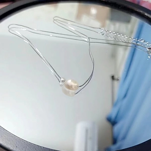 Elegant S925 silver necklace with baroque freshwater pearl on a reflective mirror surface