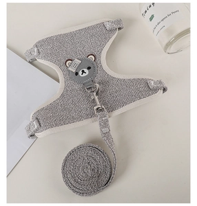 Detail of gray knitted pet harness with bear patch and metal D-ring for small animals