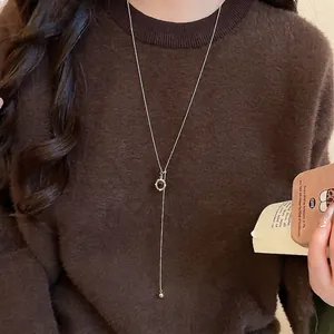 Tiger eye stone heart pendant necklace with gold chain on brown knit sweater