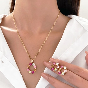 Close-up of gold necklace and stud earrings set with vibrant multi-color gemstones