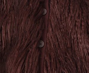 Close-up of deep burgundy faux fur cardigan with plush texture and round button detail